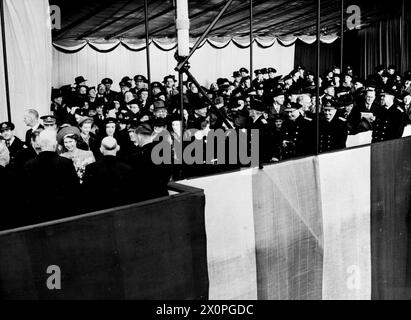 PRINZESSIN ELIZABETH STARTET GROSSBRITANNIENS GRÖSSTES SCHLACHTSCHIFF. 30. NOVEMBER 1944, CLYDEBANK. PRINZESSIN ELIZABETH STARTETE DIE HMS AVANTGARDE, DAS GRÖSSTE SCHLACHTSCHIFF, DAS AUF DEN BRITISCHEN INSELN GEBAUT WURDE. - Prinzessin Elizabeth spricht mit Werftarbeitern auf der Startplattform Stockfoto