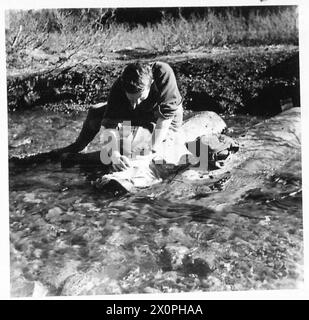 ALBANIEN: 'HINTERZIMMER-JUNGS' AN DER VORDERSEITE - N.A. 'Ginger' still von Swaythling, Lincs, ein drahtloser Betreiber, waschen Kleidung in einem nahegelegenen Fluss. Er arbeitet seit einem Jahr und sieben Monaten in Albanien. Fotografisches negativ, britische Armee Stockfoto