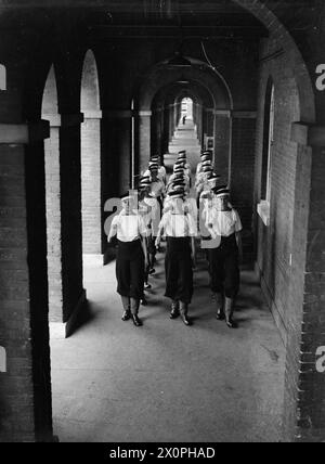 AUSZUBILDENDE FÜR LUFTWAFFENFLOTTE BEI HMS ST VINCENT, GOSPORT, AUGUST 1943 - bei HMS ST VINCENT, der Ausbildungseinrichtung der Royal Navy für Offizierskadetten der Air Branch, marschiert ein Trupp durch die feine Kolonnade Royal Navy, ST VINCENT (HMS) Stockfoto