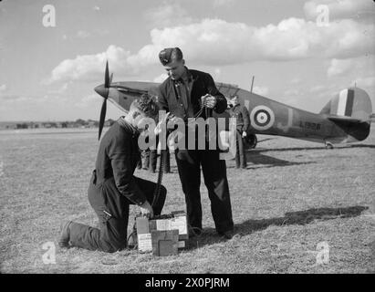 Fotografisches negativ, das Rüstungsschiffe zeigt, die 303-Zoll-Munitionsgürtel für den Hawker Hurrikan Mk I L1926 DU-J der No. 312 (Tschechische) Geschwader in Duxford während der Schlacht von Großbritannien im September 1940 vorbereiten. Stockfoto