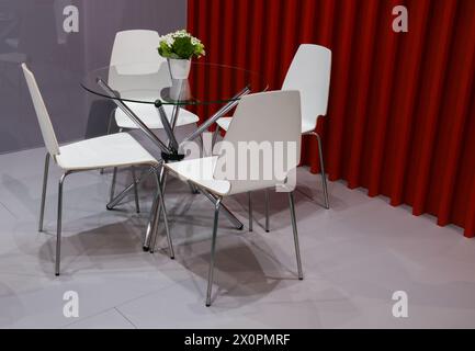 Moderne, offene Büroeinrichtung mit 4 Stühlen und rundem, transparentem Glastisch. Stockfoto
