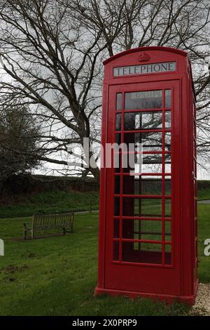 Rote Telefonbox auf Village Green, Großbritannien Stockfoto