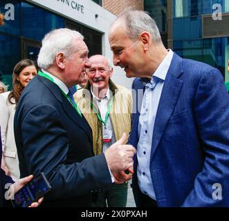 Der ehemalige Taoiseach Bertie Ahern trifft und schüttelt die Hände mit dem derzeitigen Fianna Fail Leader und Tanaiste Micheal Martin, als er am Fianna Fail Ard Fheis im Dublin Royal Convention Centre ankommt. Bilddatum: Samstag, 13. April 2024. Stockfoto