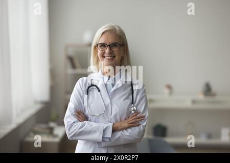 Ärztin im weißen Mantel posiert am Arbeitsplatz Stockfoto