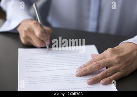 Ältere Frau unterzeichnet Geschäftsdokument, Nahansicht Stockfoto