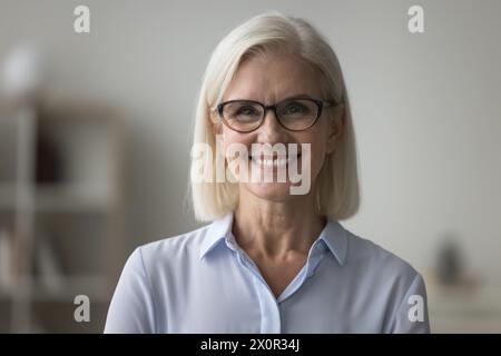 Kopffoto Porträt lächelnde reife Geschäftsfrau posiert drinnen Stockfoto