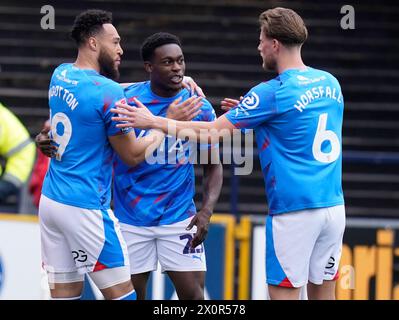 Isaac Olaofe (Mitte) von Stockport County feiert mit seinen Teamkollegen Kyle Wootton (links) und Fraser Horsfall (rechts), nachdem sie das erste Tor ihrer Mannschaft während des Spiels der Sky Bet League Two in Edgeley Park, Stockport, erzielt haben. Bilddatum: Samstag, 13. April 2024. Stockfoto