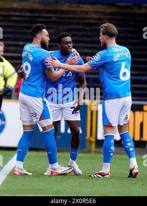 Isaac Olaofe (Mitte) von Stockport County feiert mit seinen Teamkollegen Kyle Wootton (links) und Fraser Horsfall (rechts), nachdem sie das erste Tor ihrer Mannschaft während des Spiels der Sky Bet League Two in Edgeley Park, Stockport, erzielt haben. Bilddatum: Samstag, 13. April 2024. Stockfoto