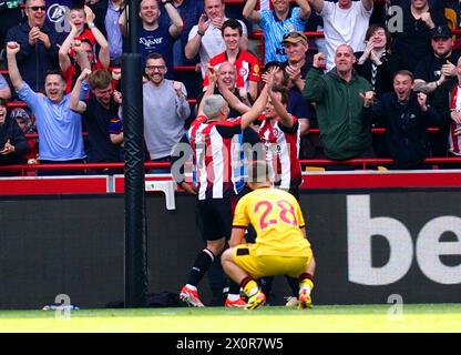 Brentfords Neal Maupay (links) und Mikkel Damsgaard feiern, nachdem Sheffield United's Ollie Arblaster (nicht abgebildet) ein eigenes Tor während des Premier League-Spiels im Gtech Community Stadium erzielt hat. Bilddatum: Samstag, 13. April 2024. Stockfoto