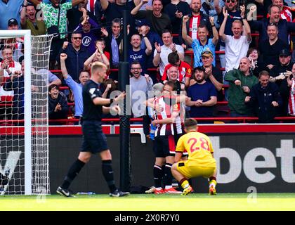 Brentfords Neal Maupay (links) und Mikkel Damsgaard feiern, nachdem Sheffield United's Ollie Arblaster (nicht abgebildet) ein eigenes Tor während des Premier League-Spiels im Gtech Community Stadium erzielt hat. Bilddatum: Samstag, 13. April 2024. Stockfoto