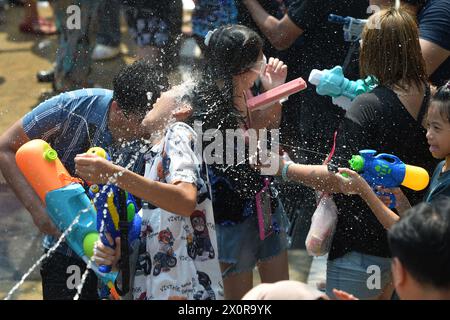 Bangkok, Thailand. April 2024. Die Menschen spritzen einander Wasser auf, um das Songkran-Festival in Bangkok, Thailand, 13. April 2024 zu feiern. Das Songkran-Festival, das traditionelle thailändische Neujahr, wird jedes Jahr vom 13. Bis 15. April gefeiert, bei dem die Menschen ihre Grüße ausdrücken, indem sie sich gegenseitig Wasser spritzen. Quelle: Rachen Sageamsak/Xinhua/Alamy Live News Stockfoto