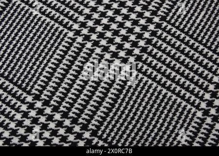 Kaschmirschal im Winter. Schwarz-weißes Gewebe mit Käfigstruktur. Textil warmes dunkles Stricktuch Hintergrund. Stockfoto