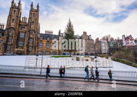 Weihnachten 2022 - Weihnachtsbaum und Schild „Edinburgh“ auf dem Hügel, mit Assembly Hall im Hintergrund, in Edinburgh, Schottland, Großbritannien Stockfoto