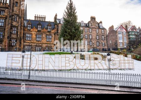 Weihnachten 2022 - Weihnachtsbaum und Schild „Edinburgh“ auf dem Hügel, mit Assembly Hall im Hintergrund, in Edinburgh, Schottland, Großbritannien Stockfoto