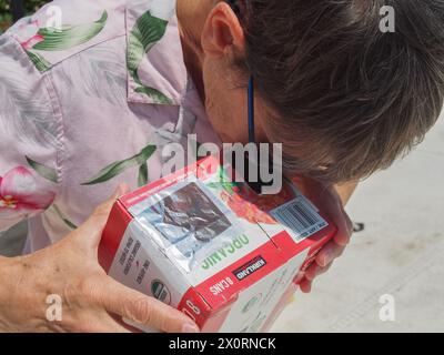 Frau, die sicher eine Sonnenfinsternis durch eine provisorische Kamera beobachtet, 8. April 2024, Florida, USA Stockfoto