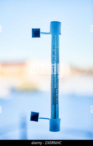 20 Grad unter Null Celsius auf einem Außenthermometer, das auf der Straßenseite mit Glasscheiben verklebt ist. Stockfoto