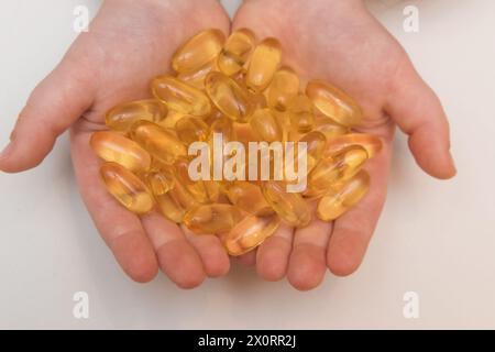 Vitaminen Omega 3 Öl in Kapseln in Hand auf beigem Hintergrund. Stockfoto