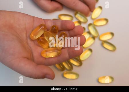 Vitaminen Omega 3 Öl in Kapseln in Hand auf beigem Hintergrund. Stockfoto