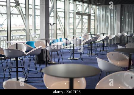 Moderne Stühle und Sessel in einem ultramodernen Saal mit Glaswänden Stockfoto