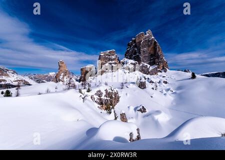 Schneetreiben schafft im Winter kunstvolle Strukturen, schneebedeckte Hänge der alpinen Dolomitenlandschaft und Gipfel der Cinque Torri-Gruppe in der Ferne Stockfoto