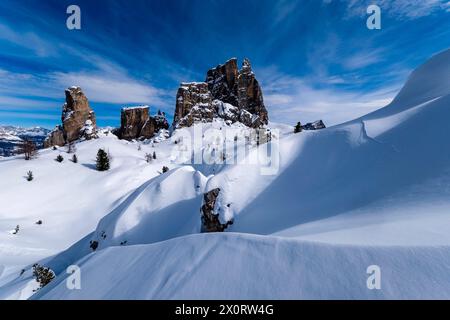 Schneetreiben schafft im Winter kunstvolle Strukturen, schneebedeckte Hänge der alpinen Dolomitenlandschaft und Gipfel der Cinque Torri-Gruppe in der Ferne Stockfoto