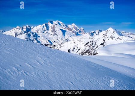 Schneebedeckte Hänge der alpinen Dolomitenlandschaft rund um den Giau Pass im Winter, die schneebedeckten Gipfel der Marmolada Gruppe in der Ferne. Cortina feucht Stockfoto