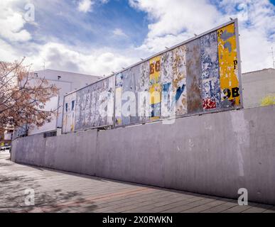 Urbane Szene mit Einer Wand und einer alten großen Werbetafel mitten in der Stadt mit Resten alter Werbung. Alt und farbenfroh Stockfoto