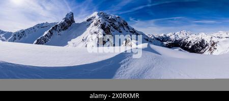 Schneetreiben schafft kunstvolle Strukturen rund um den Giau Pass im Winter, schneebedeckte Gipfel des Torre Dusso, Mt. Cernera und Marmolada in der Ferne. Stockfoto