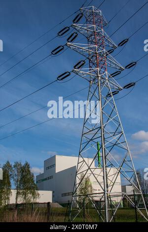 Hochspannungsleitung, die die Industrie auf Kosten der natürlichen Umwelt versorgt Stockfoto