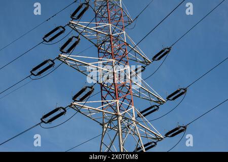 Hochspannungsleitung, die die Industrie auf Kosten der natürlichen Umwelt versorgt Stockfoto