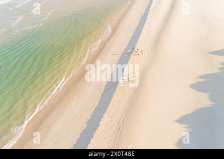 Drohnenansicht einer Gruppe von Surfern, die sich auf das Surfen am Strand vorbereiten. Stockfoto