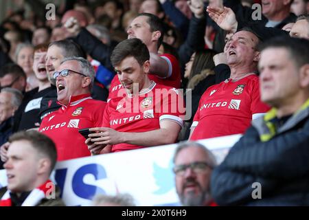 Wrexham, Großbritannien. April 2024. Wrexham-Fans singen, während sie die anderen Punkte auf ihren Mobiltelefonen überprüfen. EFL Skybet Football League Two Match, Wrexham gegen Forest Green Rovers, bei der STōK CAE Ras in Wrexham, Wales am Samstag, den 13. April 2024. Dieses Bild darf nur für redaktionelle Zwecke verwendet werden. Nur redaktionelle Verwendung, .PIC von Chris Stading/ Credit: Andrew Orchard Sportfotografie/Alamy Live News Stockfoto