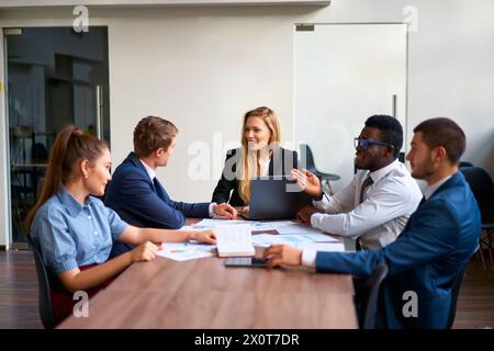 Weibliche CEO leitet Vorstandssitzungen mit multirassischen Führungskräften und diskutiert Wachstumsstrategien. Das Team analysiert Diagramme und gibt Erkenntnisse weiter. Selbstbewusst Stockfoto