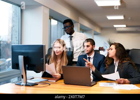 Multiethnische Geschäftsgruppe im Anzug und Krawatte im Büro. Afrikanische, arabische, kaukasische Männer und Frauen arbeiten an Projekten zusammen. Analysieren Sie Daten auf dem PC-Monitor Stockfoto