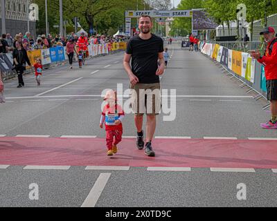 ADAC Marathon Hannover 2024 gerade einmal knapp zwei Jahre alt läuft der kleine Junge stolz neben seinem Papa dem Ziel entgegen *** ADAC Marathon Hannover 2024 knapp zwei Jahre alt läuft der kleine Junge stolz auf die Ziellinie neben seinem Vater Copyright: XBerndxGüntherx Stockfoto