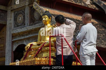 Chiang Mai, Thailand. April 2024. Ein thailändisches Volk in traditionellen Kostümen streut Wasser auf die Phra Buddha Sihing Buddha Statue während der Songkran Feiern im Wat Phra Singh Woramahaviharn Tempel. Das festliche Songkran ist auch bekannt als das Wasserfest, das am traditionellen thailändischen Neujahrstag jedes Jahr am 13. April gefeiert wird, indem Wasser gespritzt und Pulver auf die Gesichter geworfen wird, als symbolisches Zeichen für die Reinigung und das Abwaschen der Sünden aus dem vergangenen Jahr. (Foto: Pongmanat Tasiri/SOPA Images/SIPA USA) Credit: SIPA USA/Alamy Live News Stockfoto