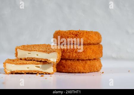Ein Stapel gebratener Camembert mit einem Cutter-Käse auf weißem Tisch Stockfoto
