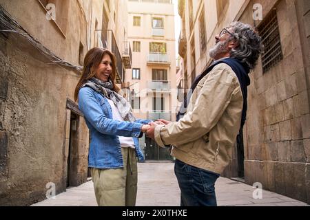 Ein attraktives Paar im Ruhestand lacht zusammen auf der Straße der Stadt. Glückliche und fröhliche Menschen. Stockfoto