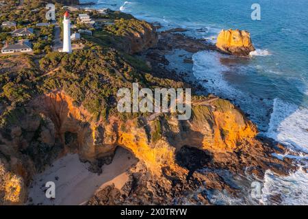 Luftaufnahme eines hohen weißen Leuchtturms auf zerklüfteten Klippen über dem Meer am Aireys Inlet an der Great Ocean Road in Victoria, Australien Stockfoto