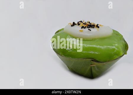 Nahaufnahme eines „umgedrehten“ thailändischen Khanom Tako Desserts mit grünem Tee und Sesamsamen, die auf Kokoscreme bestreut sind Stockfoto