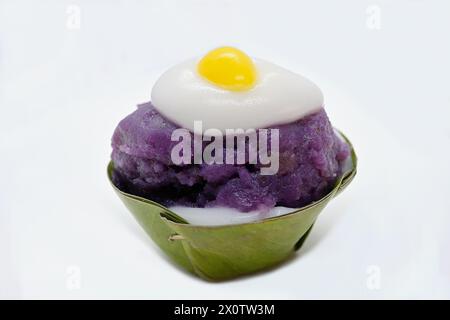 Nahaufnahme eines „umgedrehten“ Khanom Tako Thai Desserts, mit violettem Taro Topping und einem gelben Ginkgo auf Kokoscreme „Sunside Up“ Stockfoto