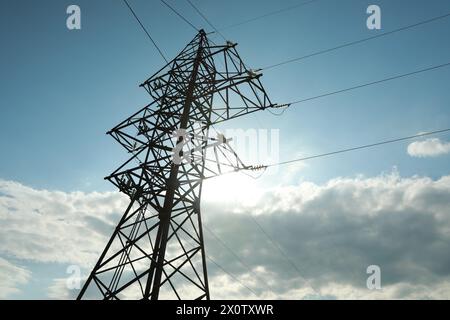 Telefonmast und Kabel gegen blauen Himmel mit Wolken Stockfoto