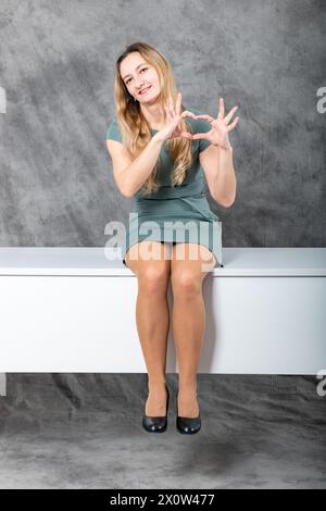 Moderner Profi: Blonde Frau, die am Schreibtisch Selbstvertrauen ausstrahlt Stockfoto