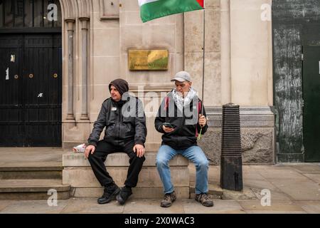London, Großbritannien. Februar 2024. Zwei Demonstranten machen eine Pause vom demonstrationsmarsch. Tausende von Menschen nehmen an dem jüngsten Nationalmarsch für Palästina in Zentral-London Teil, in dem Israel aufgefordert wird, einen sofortigen Waffenstillstand in Gaza umzusetzen. (Credit Image: © James Willoughby/SOPA Images via ZUMA Press Wire) NUR REDAKTIONELLE VERWENDUNG! Nicht für kommerzielle ZWECKE! Stockfoto