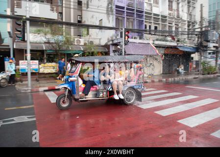 Bangkok, Thailand. April 2024. Touristen, die im TUK-TUK Thailand Bus fahren und Spaß beim Songkran Festival auf der Demokratien Straße am 13. April 2024 haben. In Bangkok. (Foto: Teera Noisakran/Pacific Press) Credit: Pacific Press Media Production Corp./Alamy Live News Stockfoto