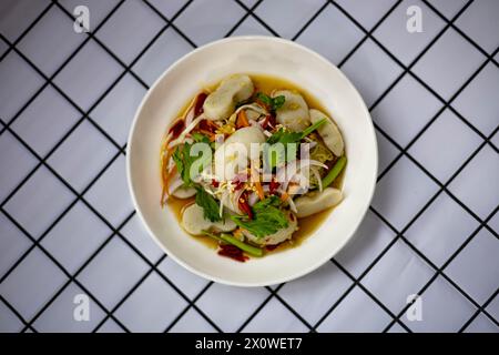Nahaufnahme von scharfem Salat mit gemischten Fischbällchen. Scharfes Essen. Stockfoto