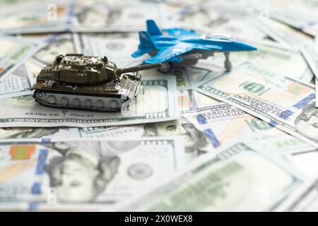 Spielzeugtank auf US-Dollar-Banknoten aus nächster Nähe. Das Konzept der Kriegskosten, der Militärausgaben und der Wirtschaftskrise Stockfoto