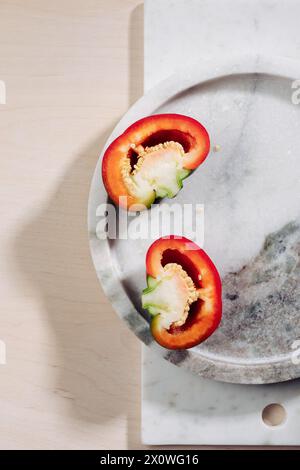 Hälften roten runden Pfeffers auf einem Marmortablett. Stockfoto