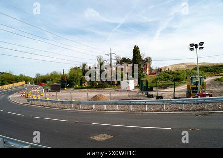 Wendover, Großbritannien. April 2024. HS2 hat nun einen Teil der Ellesborough Road in Wendover, Buckinghamshire, im Rahmen der HS2 High Speed Rail Construction Works vorübergehend neu ausgerichtet. Hinter den verbleibenden Hütten wurde eine neue Straße gebaut (im Bild). Eine Reihe von Ferienhäusern in der Ellesborough Road wurde von HS2 abgerissen, während einige zum Pflichtkauf wurden, aber leer bleiben. Der Teil der Ellesborough Road vor den verbliebenen Cottages ist heute eine Sackgasse und nur für die Bewohner zugänglich. Dies führt zu Verwirrung, da Autos, Fußgänger und Radfahrer immer noch auf der Straße und in der Region unterwegs sind Stockfoto