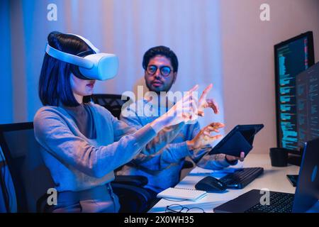 asiatische und indische Entwickler devops Team testet Virtual Reality Coding Promgram App nachts im Büro Stockfoto